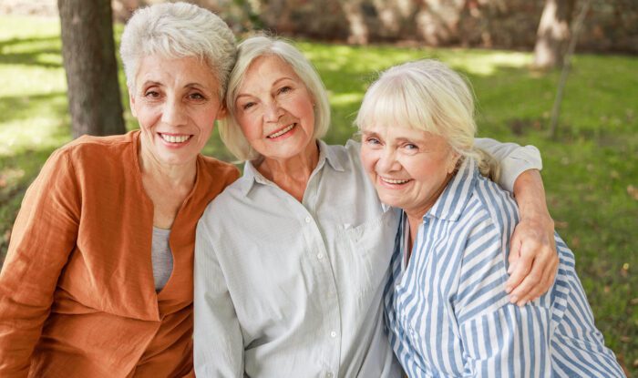 3 elderly woman pose for a photo together